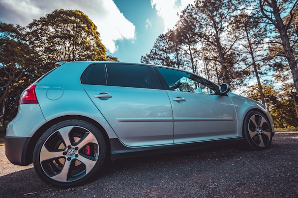 A bright hatchback shining under the sun, waiting for its next driver.