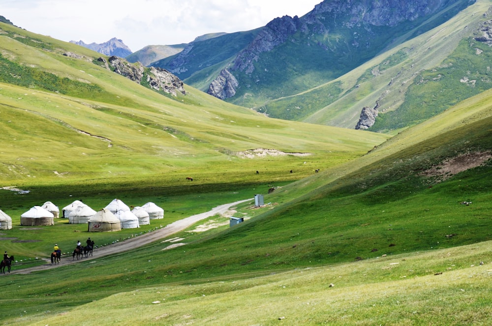 Maison Blanche sur un champ d’herbe verte près de la montagne pendant la journée