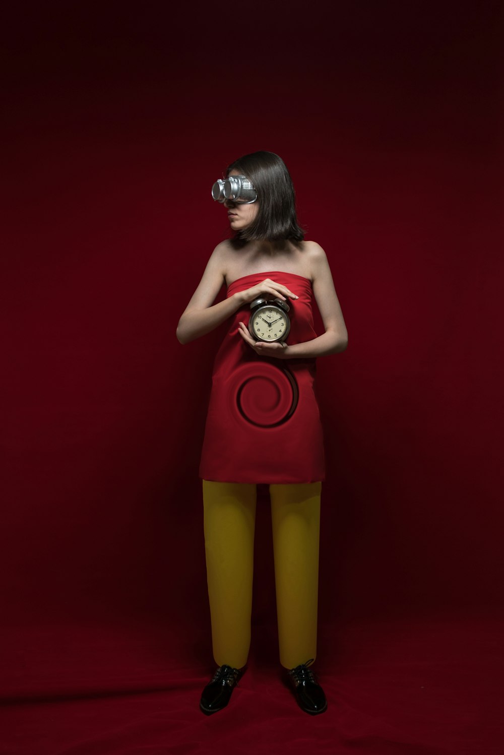 woman in red tank top and yellow shorts holding red and silver trophy