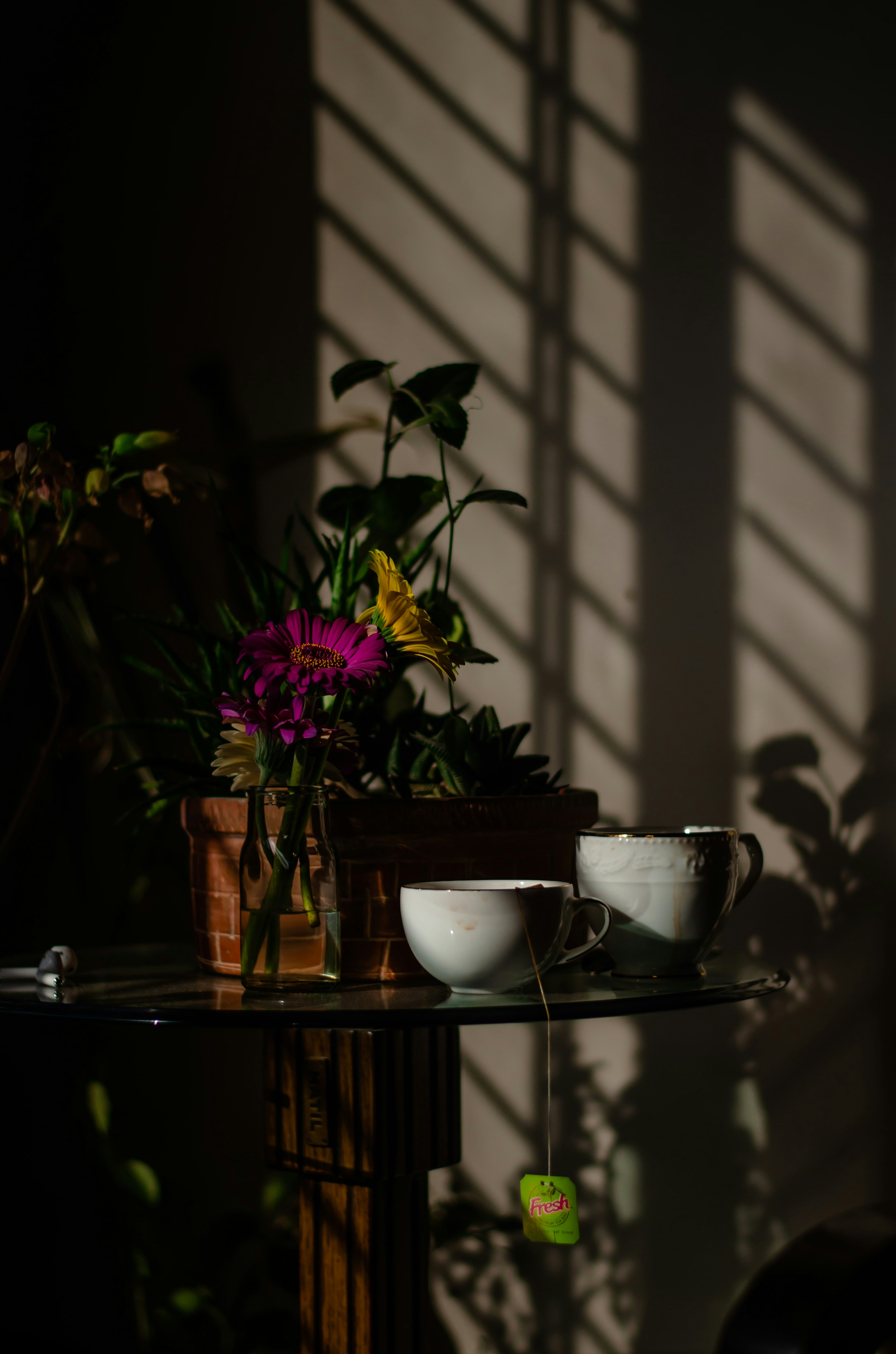 purple flowers in white ceramic bowl on brown wooden table