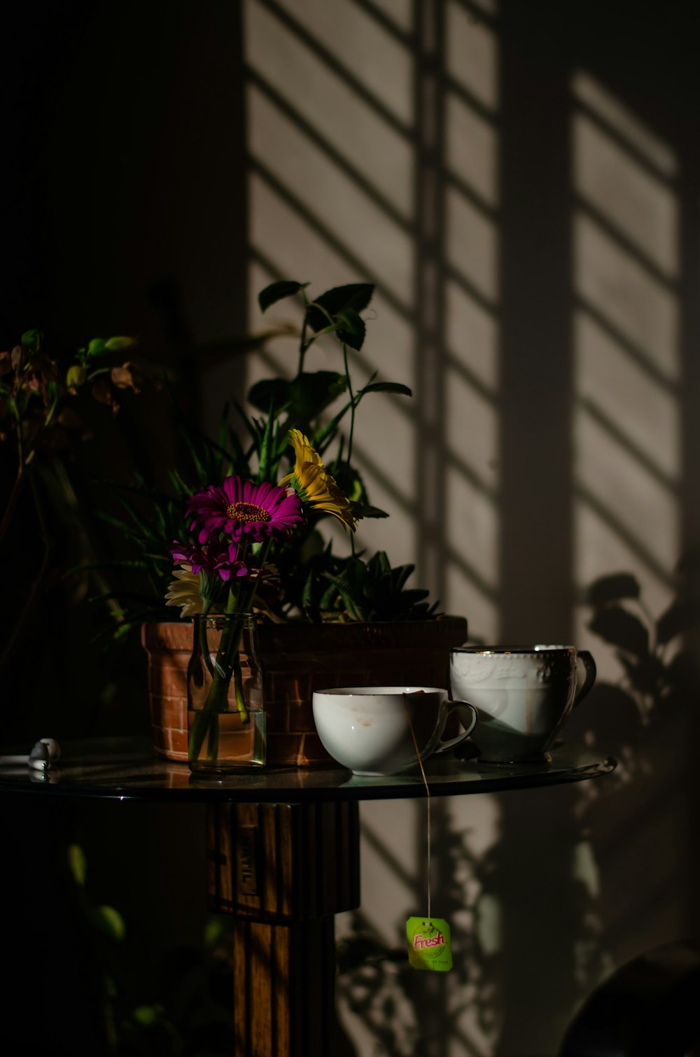 purple flowers in white ceramic bowl on brown wooden table