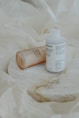 white plastic bottle on white textile