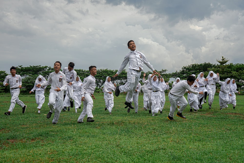 group of people in white uniform on green grass field during daytime