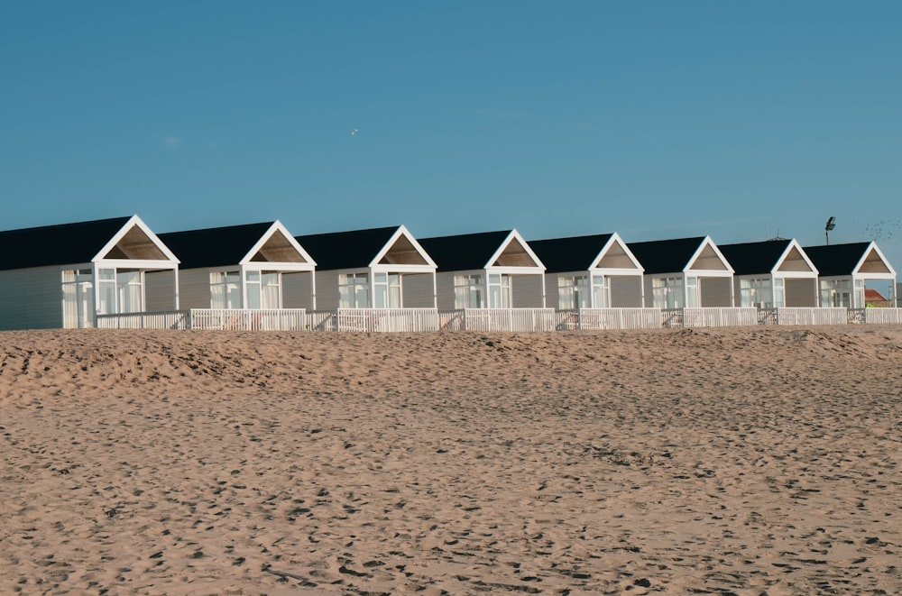 white and gray wooden houses on brown sand under blue sky during daytime