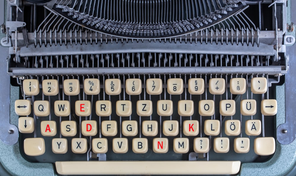 máquina de escribir en blanco y negro sobre mesa de madera marrón