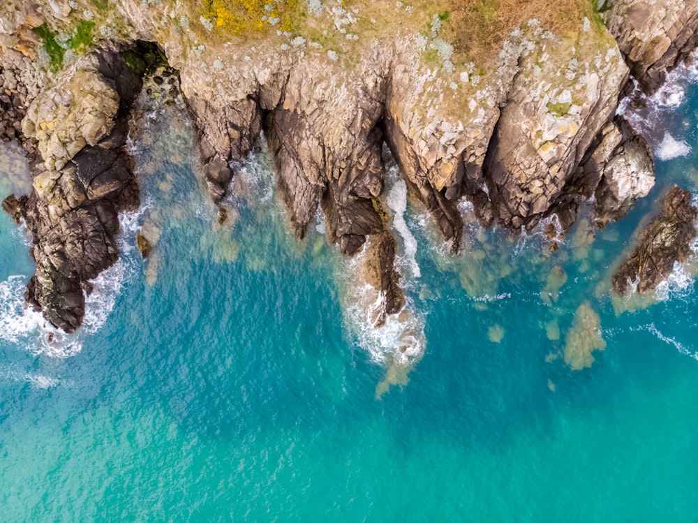 brown rock formation beside blue body of water during daytime