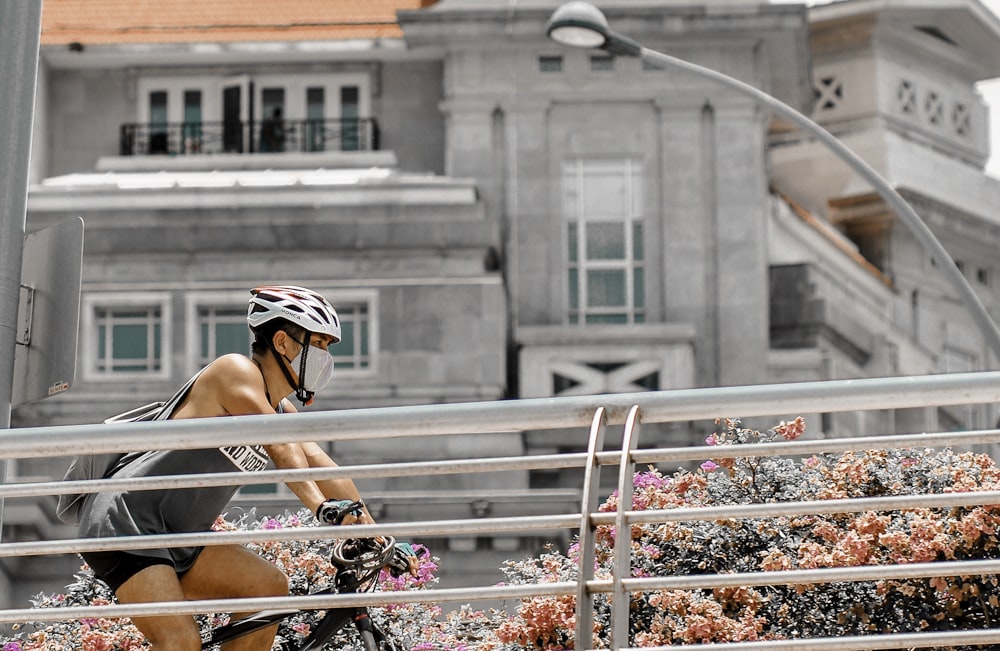 woman in white and black helmet sitting on white metal railings during daytime