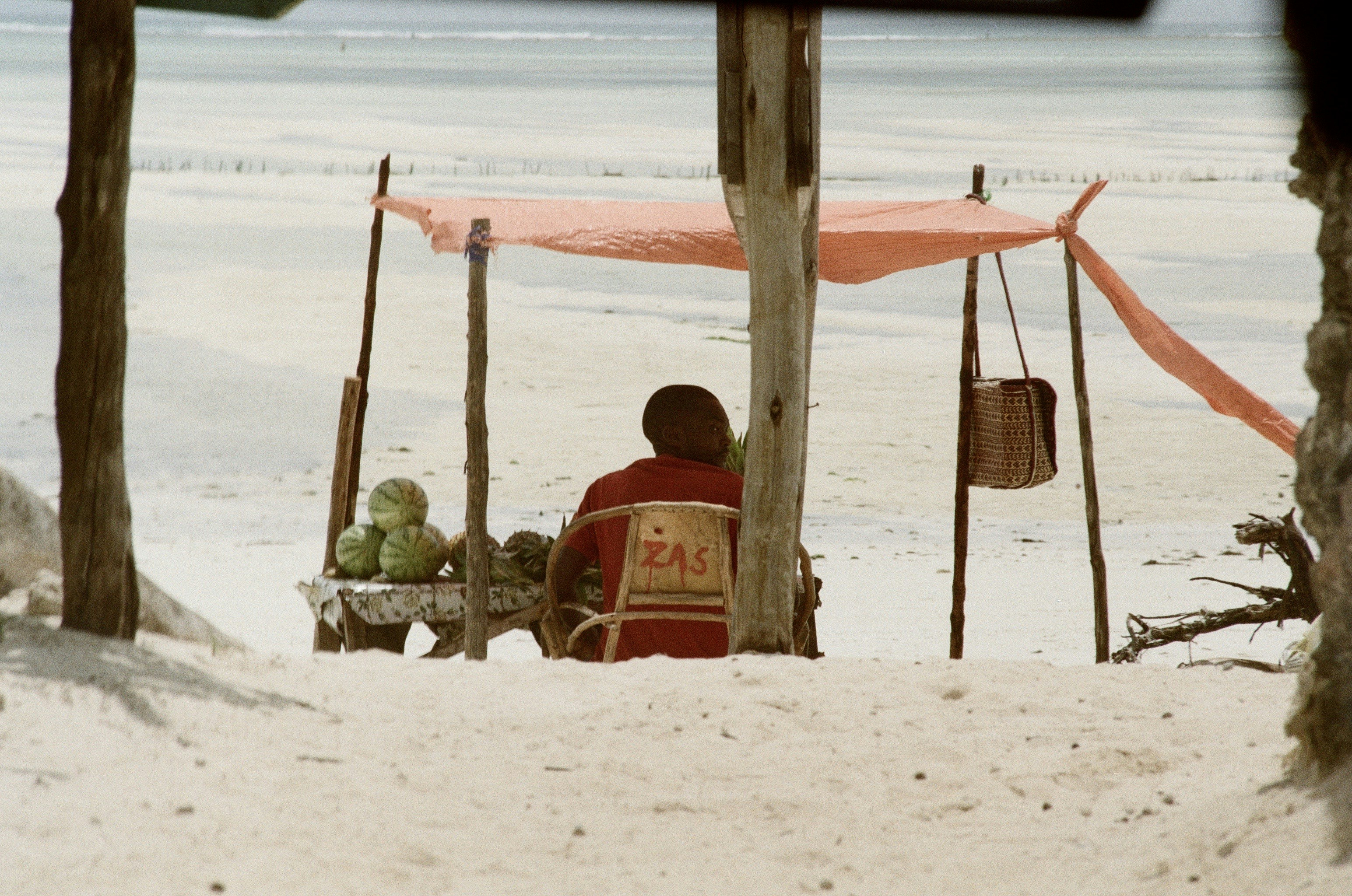 2 red and yellow beach chairs on white sand beach during daytime