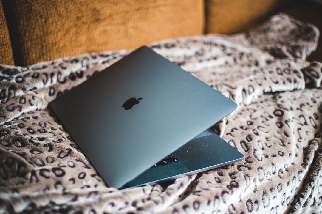 silver macbook on white and brown textile