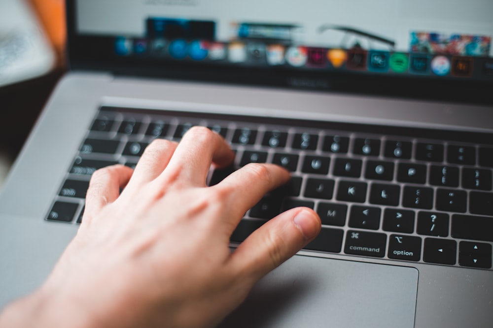 person using macbook pro on table