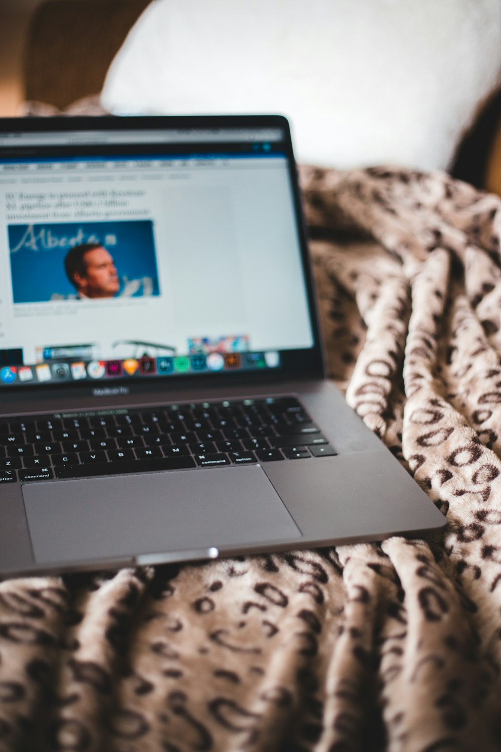 macbook pro on brown and white textile