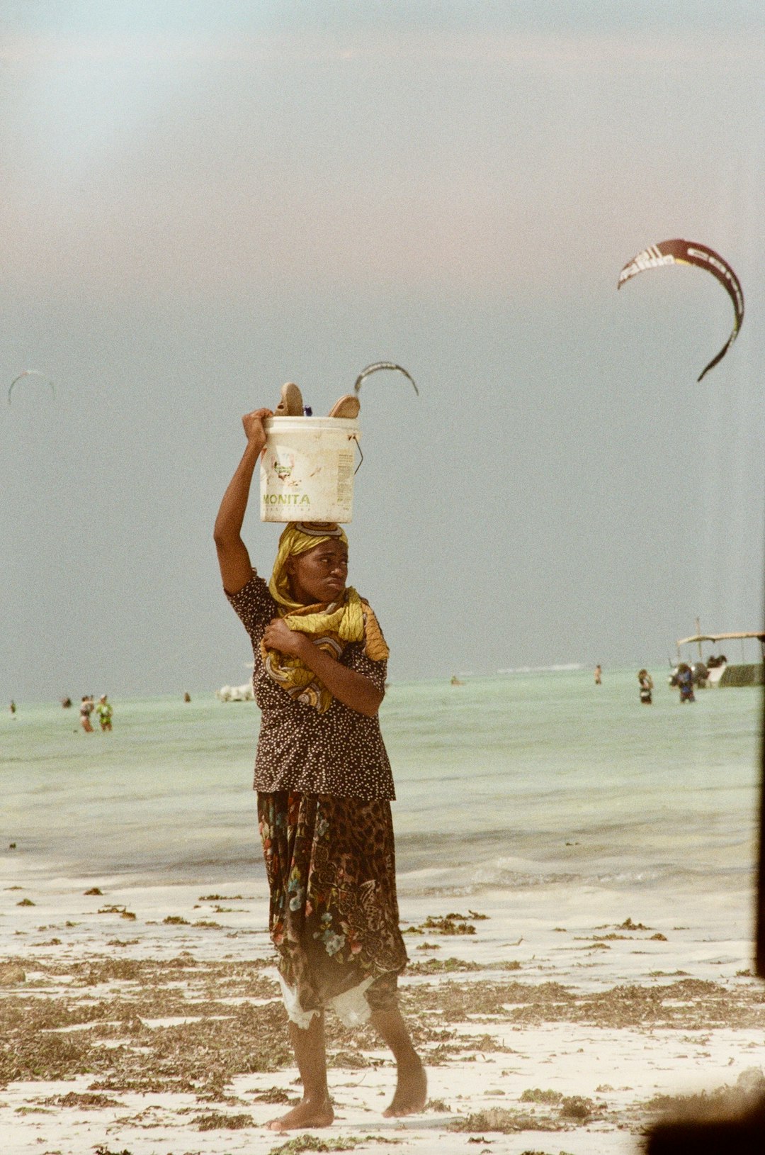 woman in yellow and black dress holding white plastic bucket