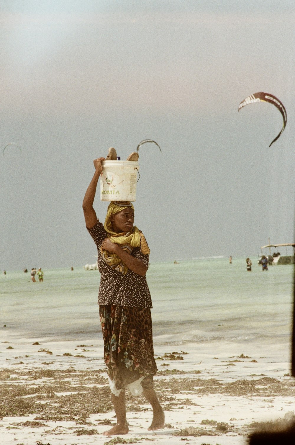 woman in yellow and black dress holding white plastic bucket