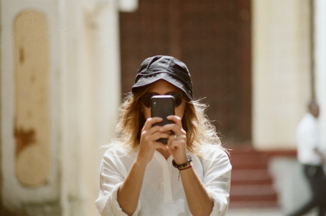 woman in white long sleeve shirt holding gold iphone 6