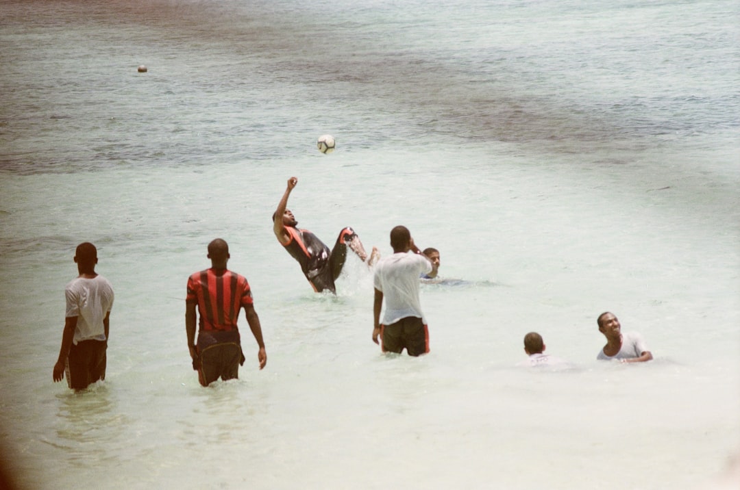 group of people playing on beach during daytime
