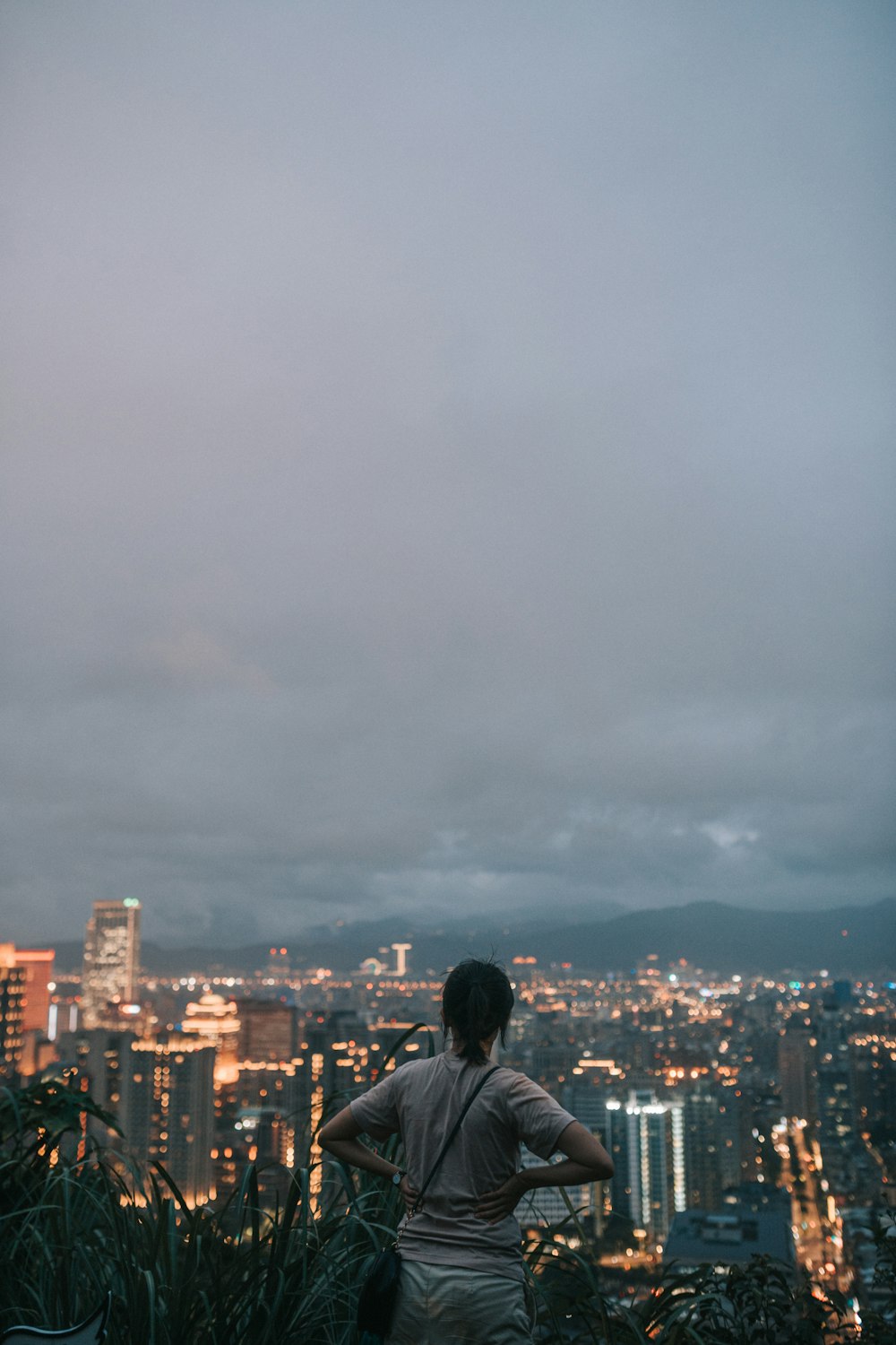 homem em jaqueta preta olhando para edifícios da cidade durante o dia