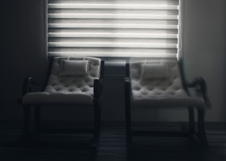 white window blinds near black wooden chair