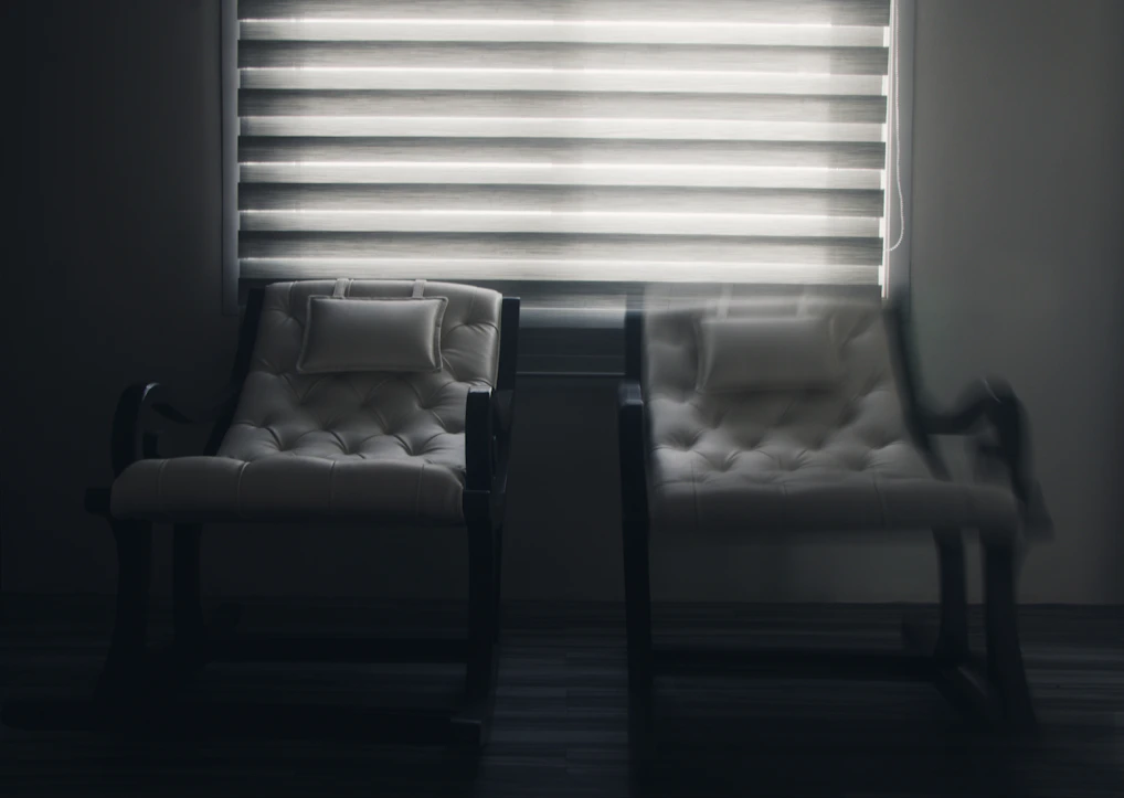 white window blinds near black wooden chair