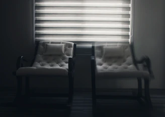 white window blinds near black wooden chair