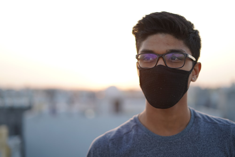 man in white crew neck shirt wearing black knit cap and black framed eyeglasses