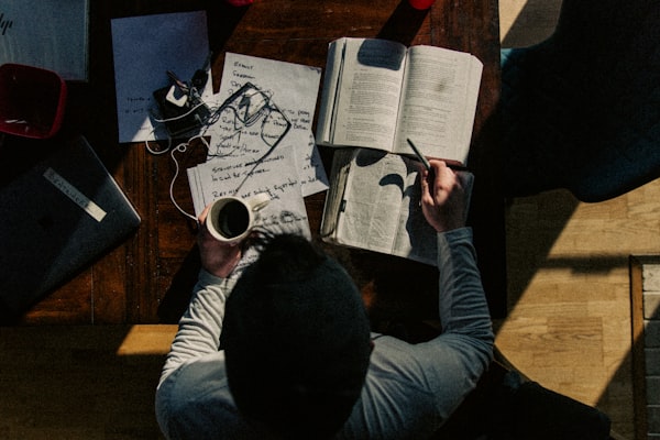 a person reading/studying with a cup of coffee