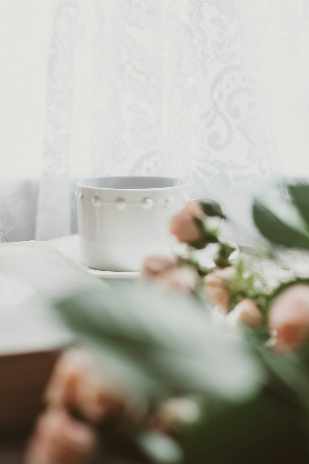 white ceramic mug on white table