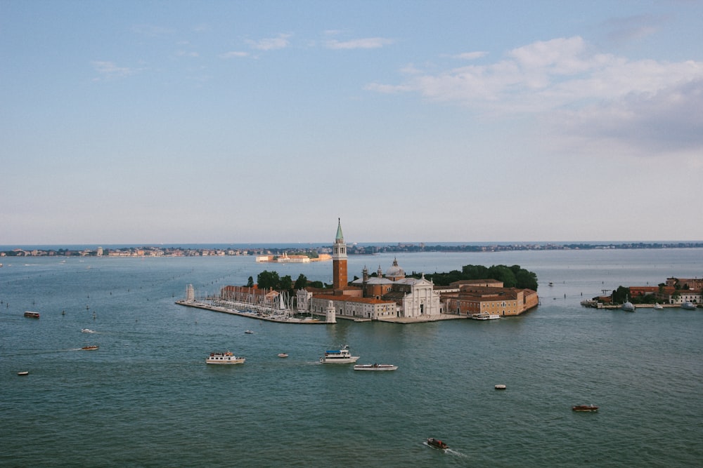 white and brown boat on sea near city buildings under white clouds during daytime