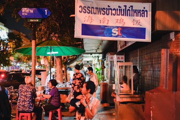 Friends posing with street food stalls in vibrant night market in Thailand
