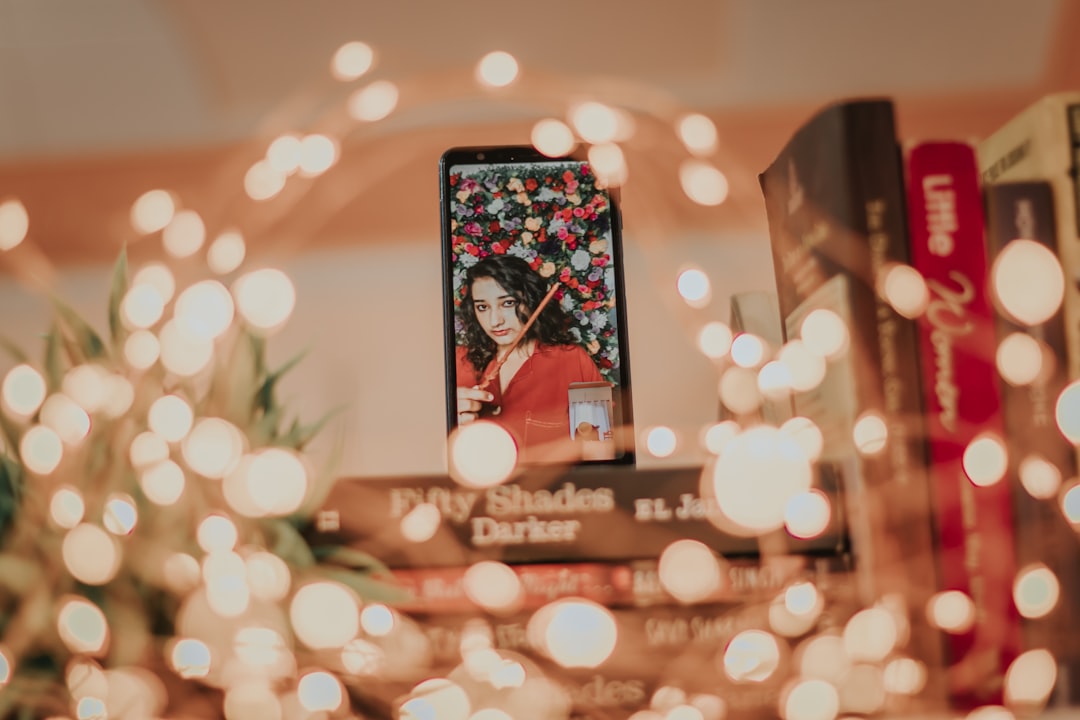 black smartphone displaying woman in red shirt