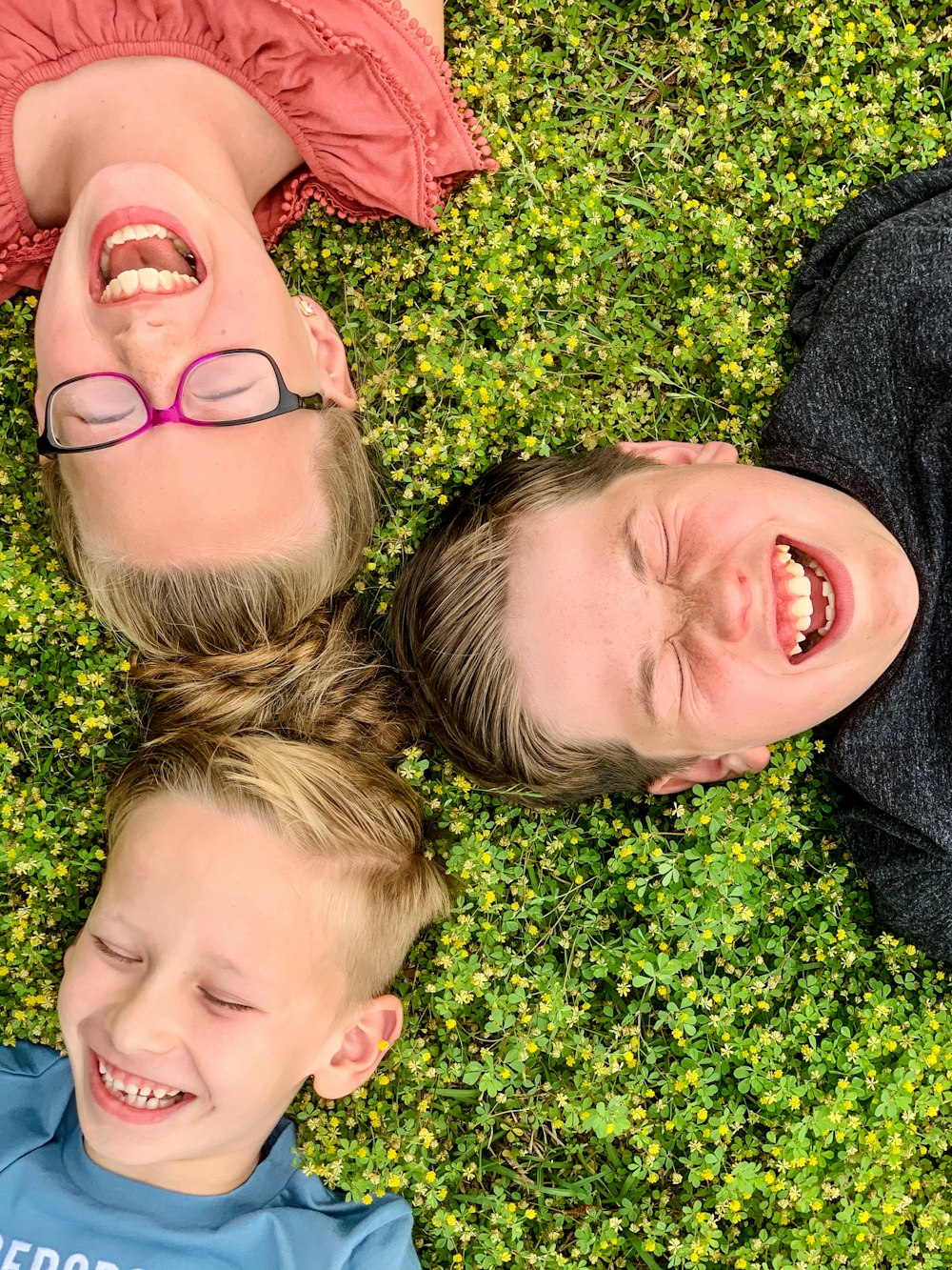 man and woman lying on green grass field during daytime