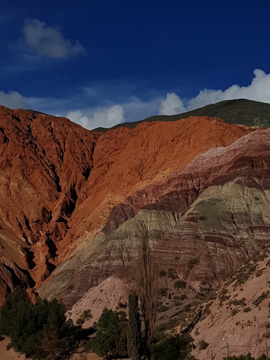 brown rocky mountain under blue sky during daytime in Purmamarca Argentina