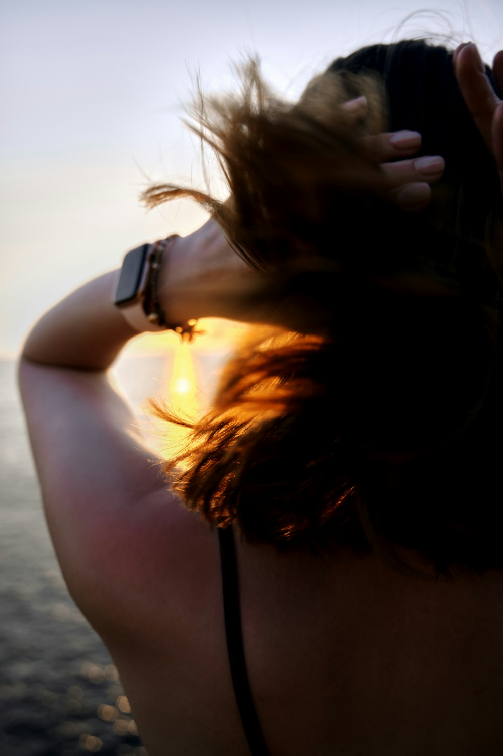 donna in bikini top nero che indossa orologio nero