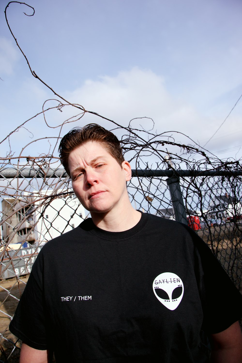 man in black crew neck shirt standing near gray metal fence during daytime