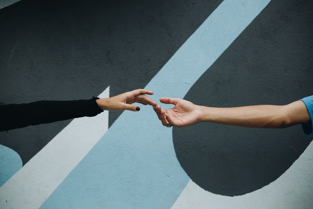 person in black long sleeve shirt and black pants doing heart hand sign