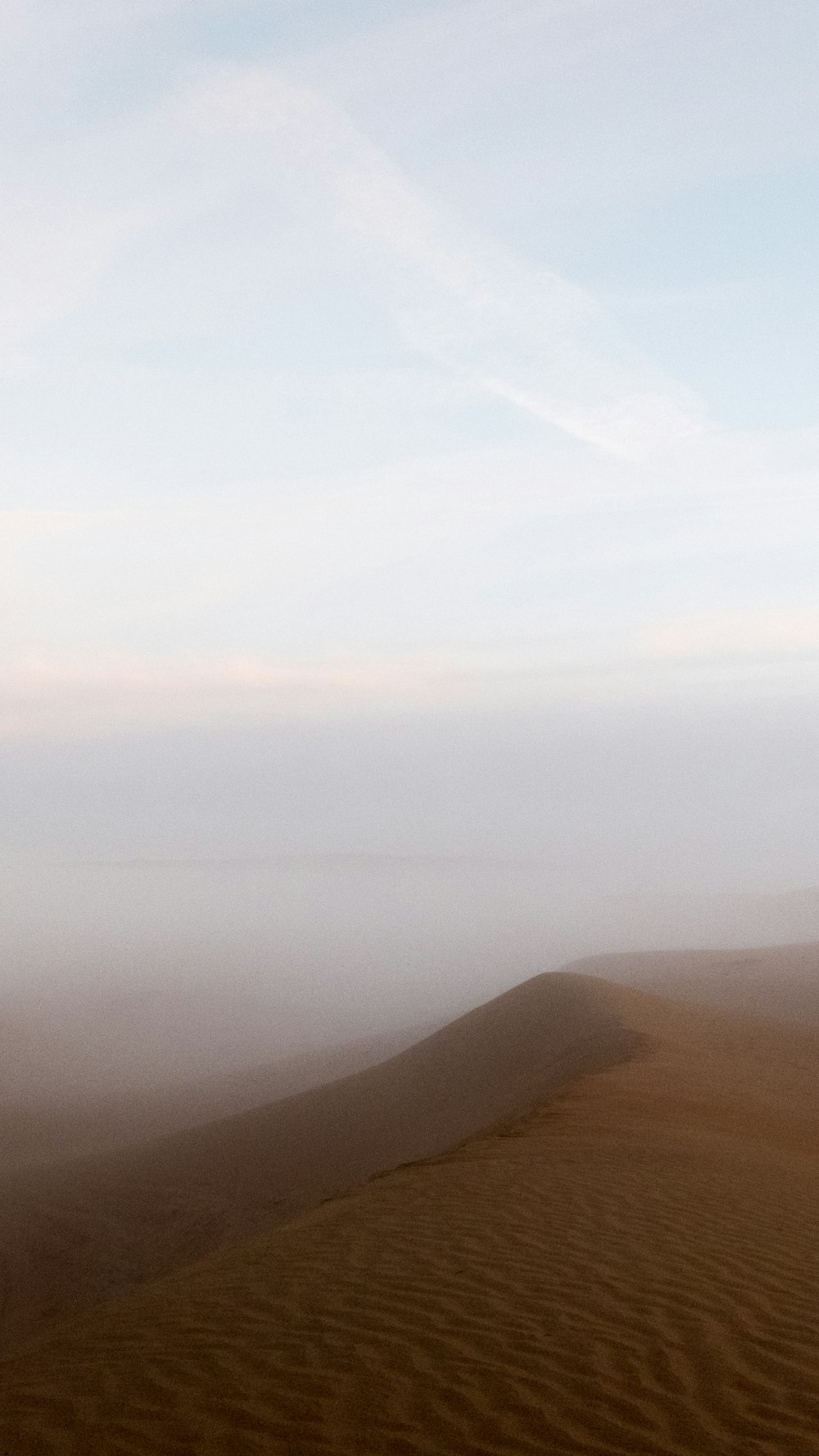 Montagnes brunes sous des nuages blancs pendant la journée