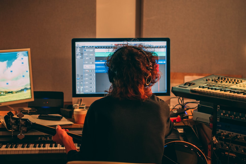 woman in black long sleeve shirt sitting in front of computer monitor