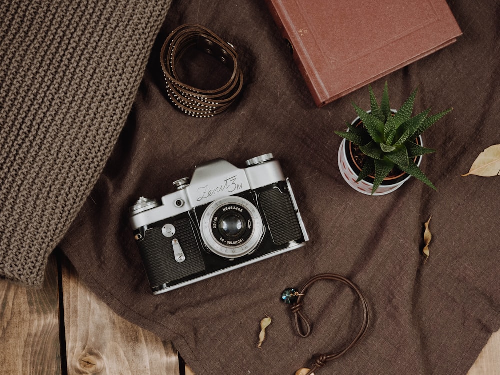 black and silver dslr camera on brown textile