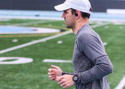 a man standing on a field with a white hat on