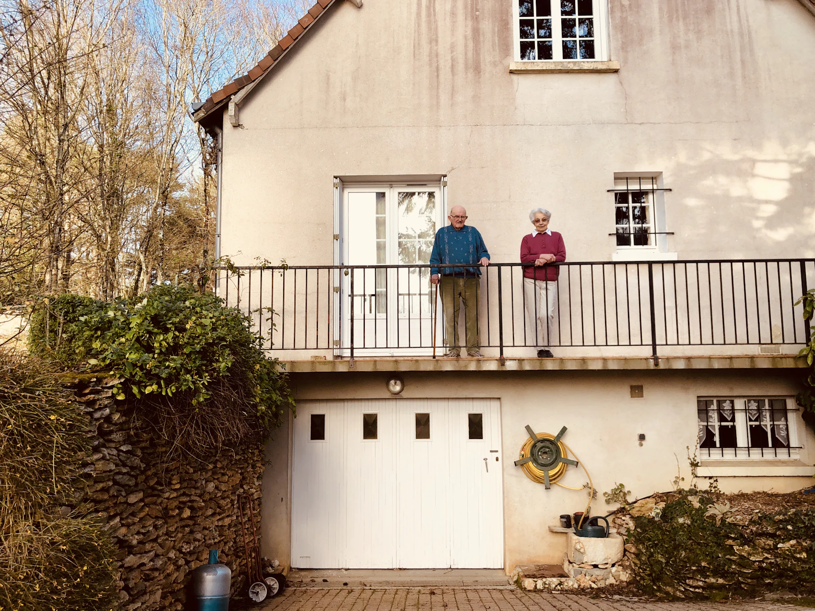 Two-story home with a balcony above the garage