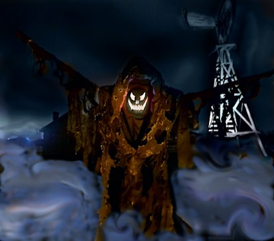 A spooky scarecrow-like figure with a glowing, sinister face and sharp teeth stands in a foggy field. The figure is cloaked in tattered, dark brown fabric, adding to its eerie presence. In the background, a windmill looms against an ominous, dark sky.