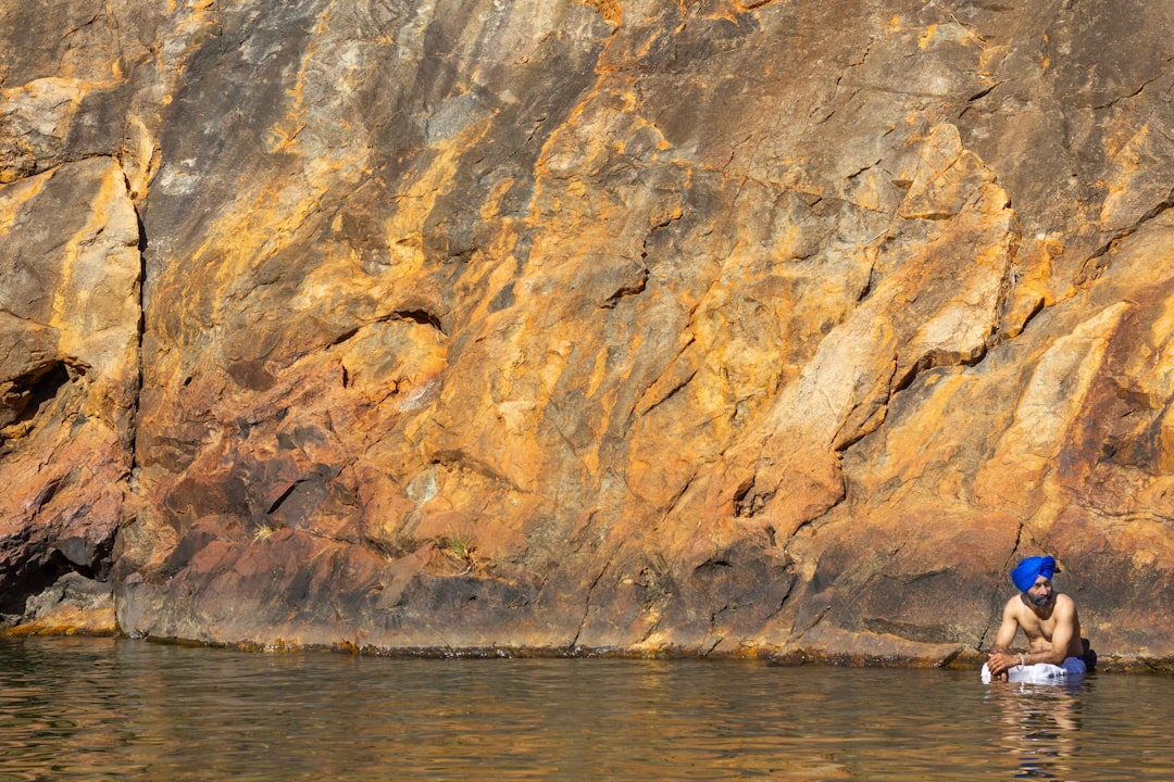 brown rock formation beside body of water during daytime