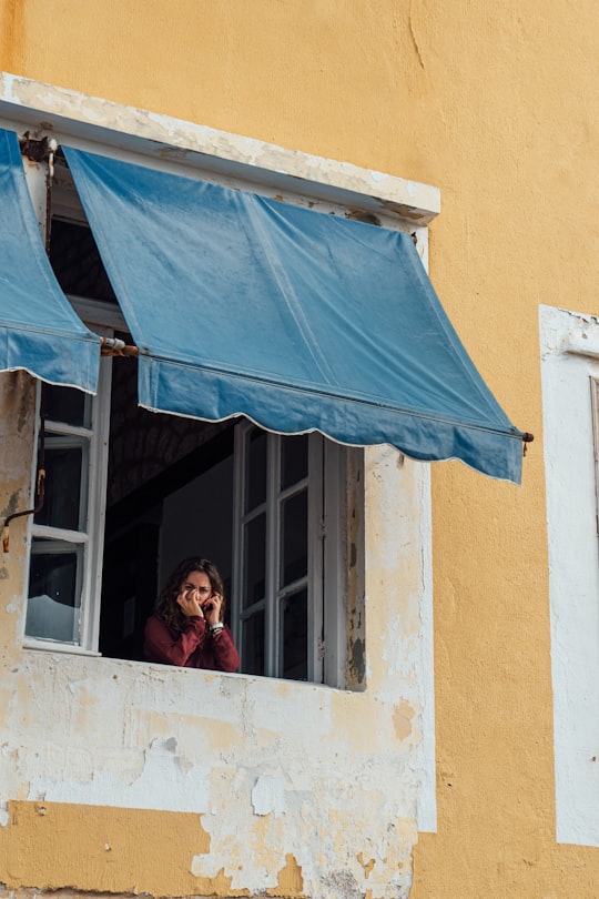 woman in red and black plaid shirt sitting on window during daytime in Beyrut Lebanon