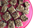 Assortment of wholesome dessert bars with visible seeds and dried fruits on parchment paper