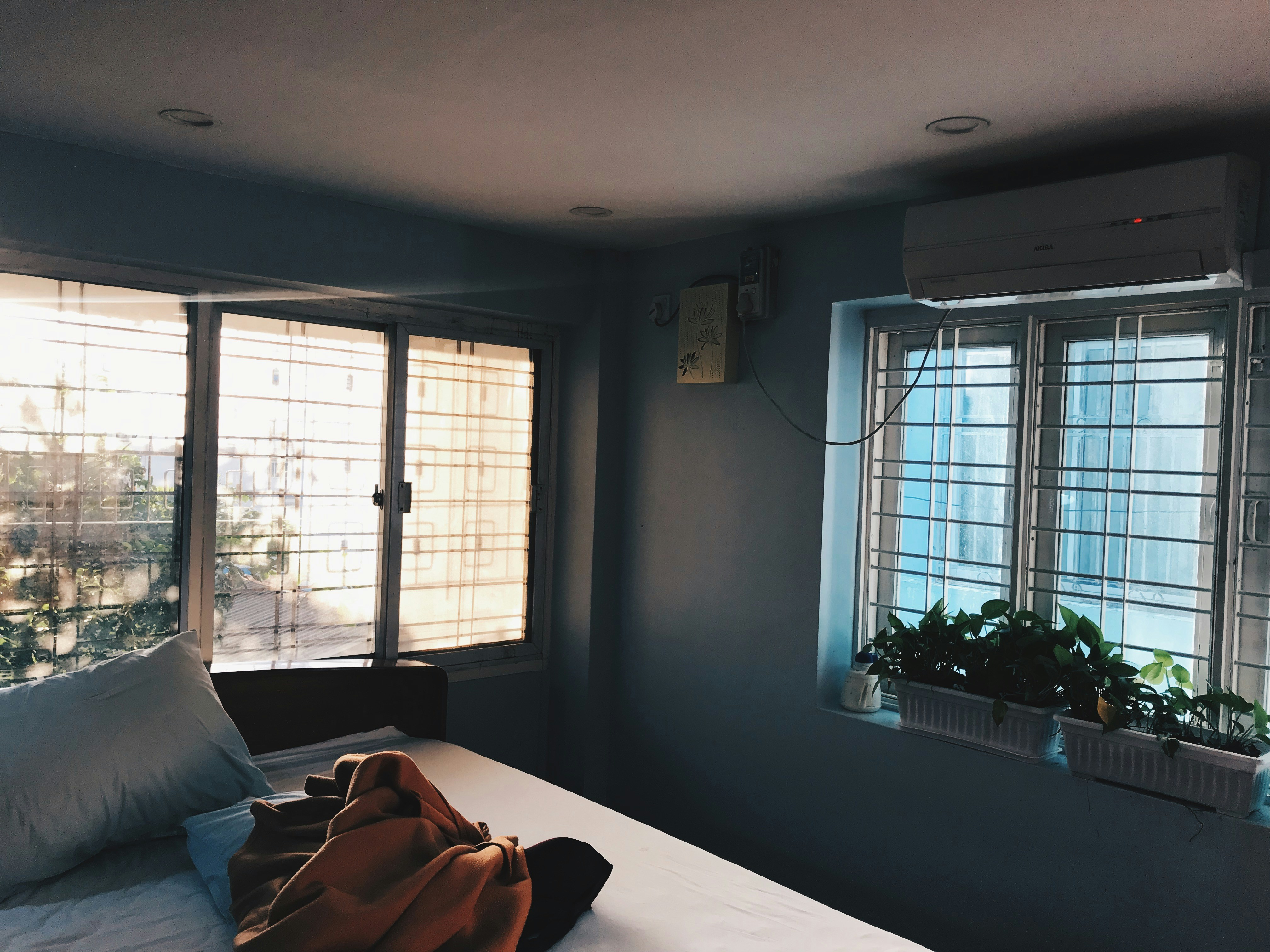 sunlit bedroom with light-colored, low-VOC paint and open windows - eco friendly apartments chicago