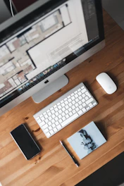 silver imac beside apple magic keyboard and magic mouse on brown wooden desk