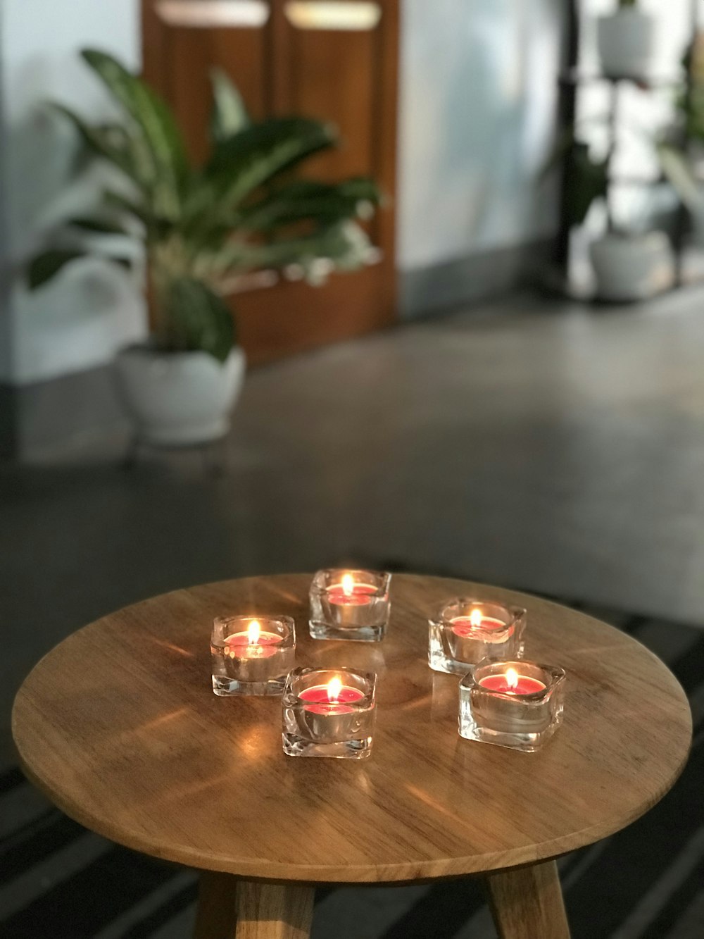 茶色の木製テーブルの上の透明なガラスのキャンドルホルダー