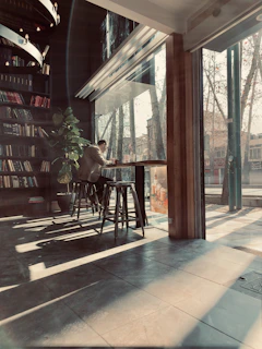 A warm café corner where a reader is immersed in a graphic novel, sunlight streaming in.