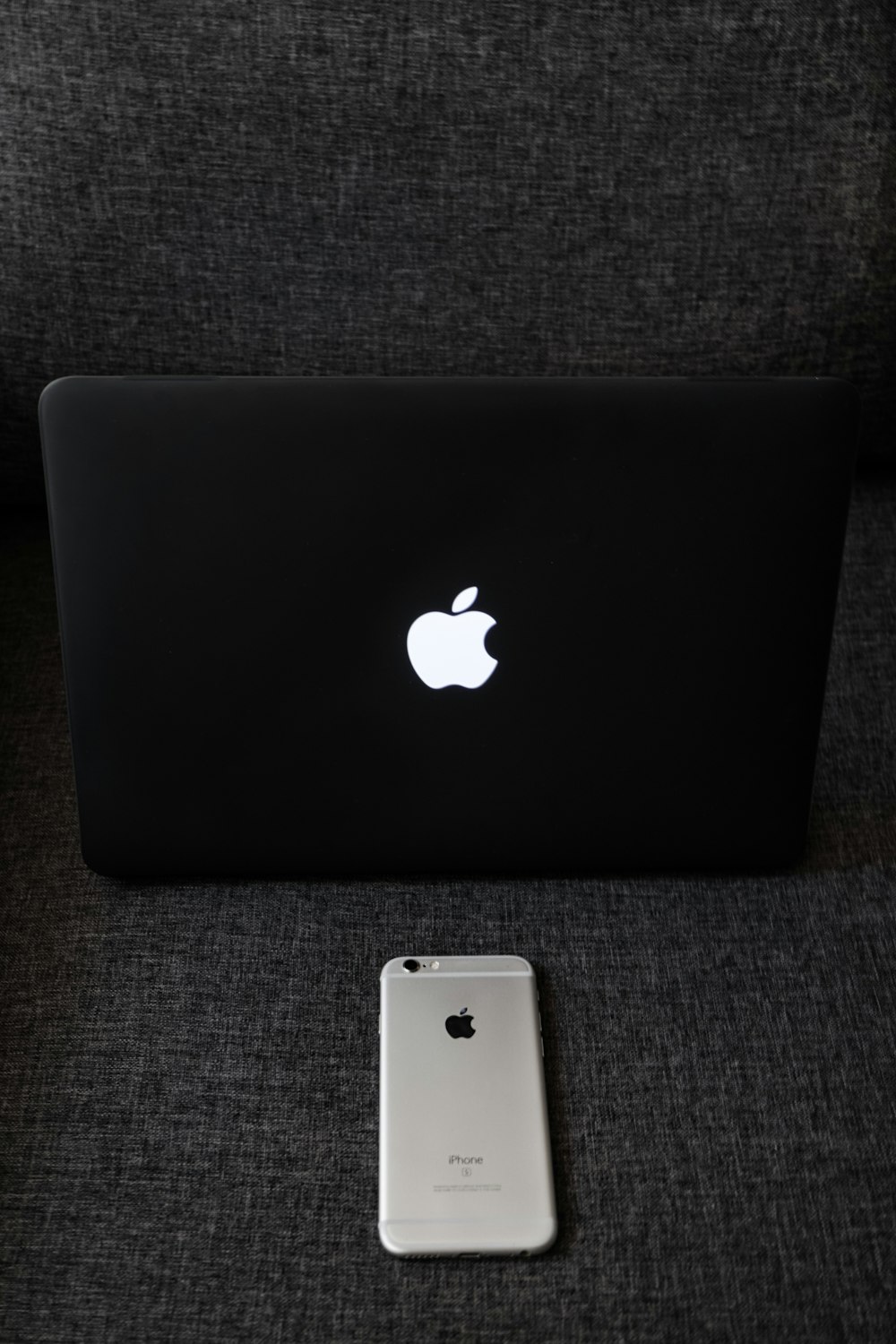 silver macbook on gray textile