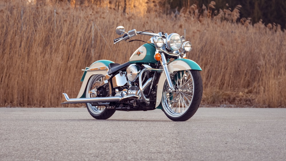 blue and silver cruiser motorcycle on gray asphalt road during daytime