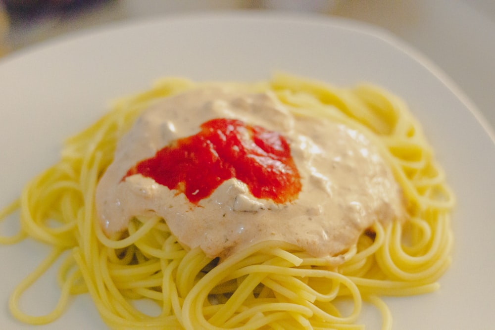 pasta with red sauce on white ceramic plate